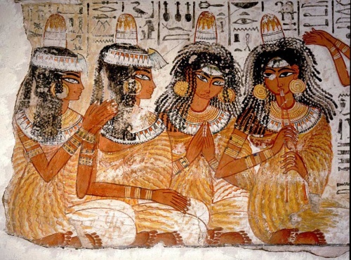 約3300年前の晩さん会。頭に円すい形の物体を載せた女性たちが描かれている。この円すいは古代エジプト美術によく登場するが、単なるシンボルか、実際に使われていたものかという議論を呼んできた。（PHOTOGRAPH BY WERNER FORMAN, UNIVERSAL IMAGES GROUP/GETTY）