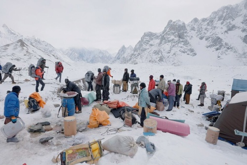 カラコルム山脈中央部、ゴドウィン・オースティン氷河上にあるK2ベースキャンプに集まったポーターたち。ここは山頂を目指す際の拠点であり、休息所でもあるが、気象条件が悪ければ滞在することすら厳しいものになる。(PHOTOGRAPH BY SANDRO GROMEN-HAYES)
