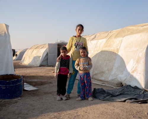 13歳のシャハドさん(中央)は、2019年のトルコによる攻撃後、トルコとの国境に近いラース・アル=アインから弟2人を連れて脱出し、ワショカニ難民キャンプに身を寄せた。両親は一緒ではなかった。シリア北東部のハサカ近郊にあるワショカニ難民キャンプでは1万人以上が暮らしている。難民キャンプの人々はフルネームを公開しないことを希望した。(PHOTOGRAPH BY WILLIAM KEO)