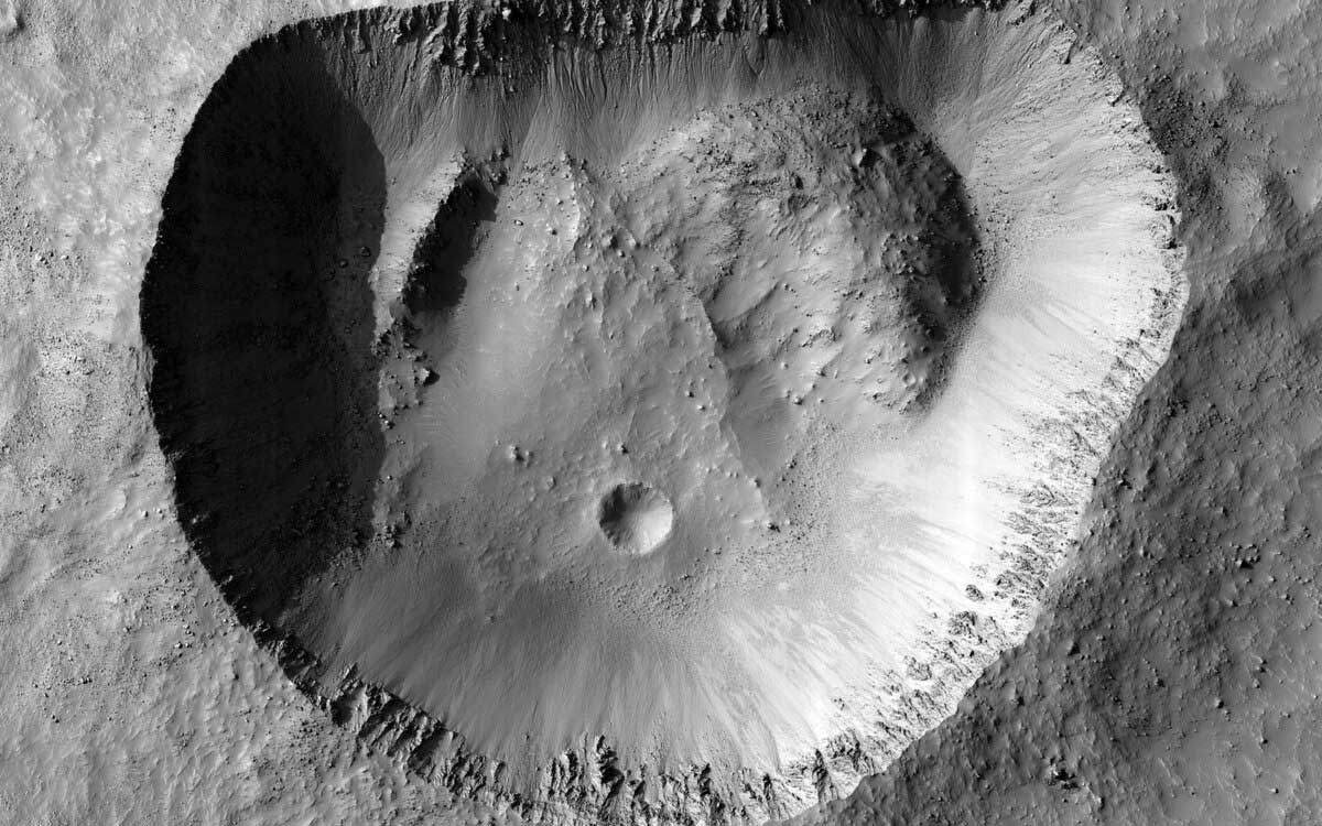 クレーターの縁の細部や、内壁の上や外側にある個々の岩が鮮明に写った画像。これは、このクレーターがさほど古いものではなく、大きく変化していないことを示している。奇妙な形をしているが、これはおそらく最初からこのように形成されたものと思われる。（IMAGE BY NASA/JPL-CALTECH/UNIVERSITY OF ARIZONA）