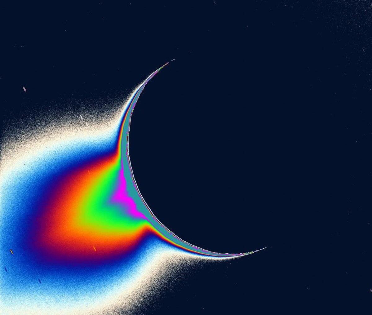 土星探査機カッシーニが撮影した、太陽を背景にしたエンケラドスの画像。南極域から噴水のように物質が噴き出しているのがわかる。（IMAGE BY NASA/JPL/SPACE SCIENCE INSTITUTE）