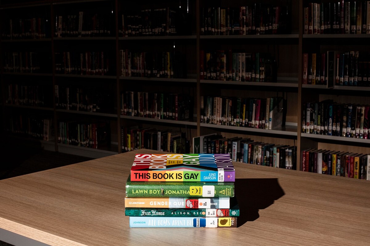 米ニュージャージー州アナンデールにあるノースハンタードン地区高校の図書室で撤去処分を免れた5冊の本。現在、米国で一部の本を禁止しようとする動きがかつてないほど高まっている。なかでも標的にされやすいのが、この写真にもあるLGBTQ+を扱った本だ。（Photograph by Bryan Anselm, Redux）