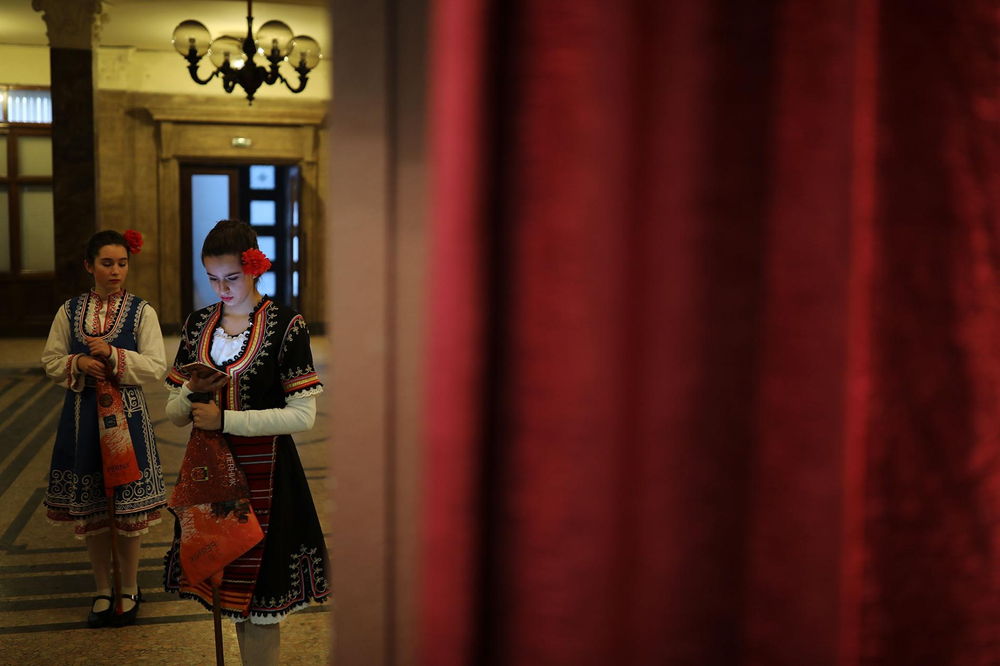 開会式でブルガリアの民族舞踊を披露する若いダンサーたち。寒さを避けるため、屋内で待機している。（PHOTOGRAPH BY DAN KITWOOD, GETTY）