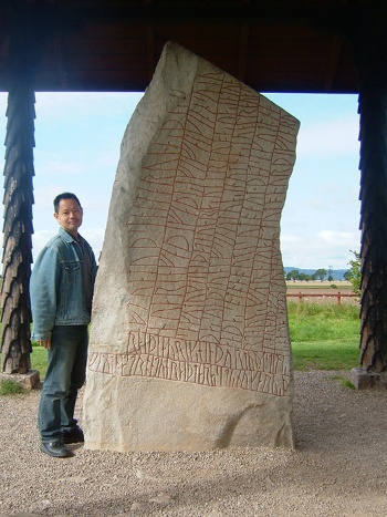 これは中世のルーン文字の石碑(Altuna, Rök; スウェーデン)と伊藤さん。2009年8月、スウェーデンのウプサラ大学で「国際サガ学会」に出席した後、石碑を巡る旅行中に訪れた際のひとコマ。(写真提供:伊藤盡)