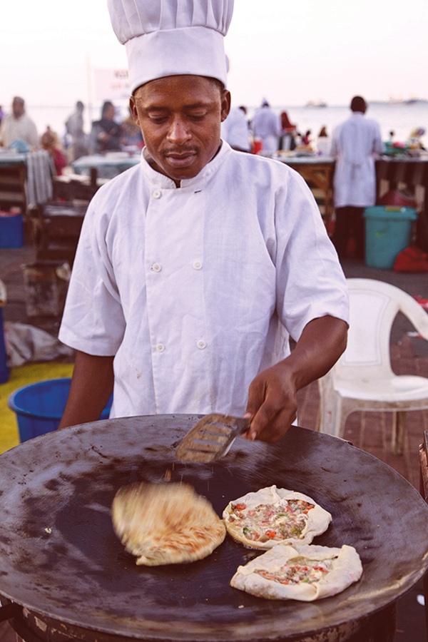 ストーンタウンのフォロダニ・ガーデンでザンジバル・ピザを焼く料理人。（Photograph by Charles O. Cecil/Alamy）